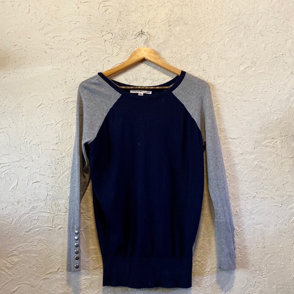 Black and grey sweater with buttons along the back